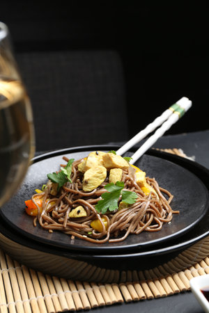 Stir-fry. Tasty noodles with meat and vegetables served on dark tableの写真素材