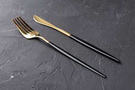 Set of beautiful cutlery on black table