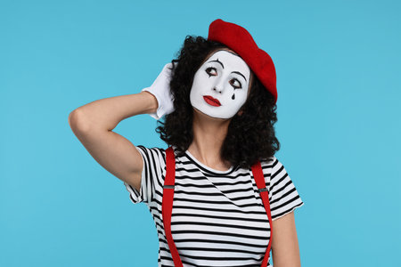 Funny mine with beret posing on light blue backgroundの写真素材