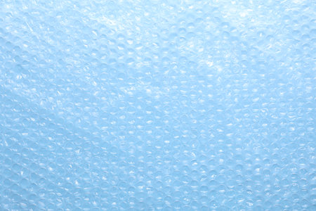 Transparent bubble plastic wrap on light blue background, top view