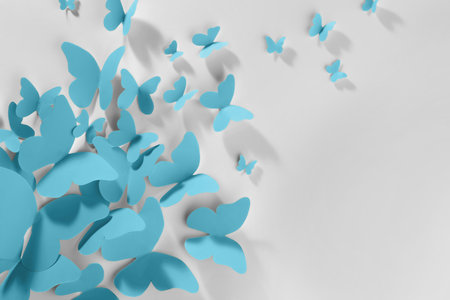 Light blue paper butterflies on white wallの写真素材