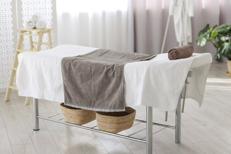 Comfortable massage table with clean towels in spa centerの写真素材