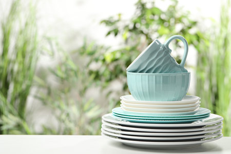 Beautiful ceramic dishware and cup on white table outdoors, space for textの写真素材