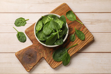 Fresh spinach leaves on light wooden table, top viewの写真素材