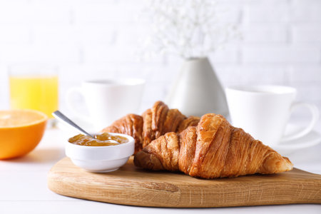 Croissants and jam on white wooden table. Tasty breakfastの写真素材