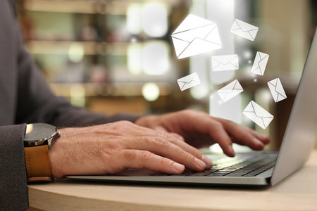Email. Man using laptop at table, closeup. Letter illustrations over deviceの写真素材