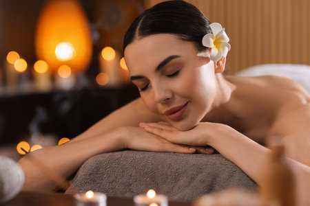 Spa therapy. Beautiful young woman lying on massage table in salonの写真素材
