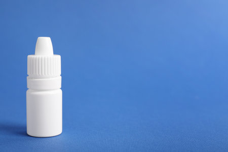 Bottle of medical drops on blue background, space for textの写真素材