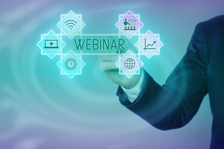 Webinar. Businessman using virtual screen with icons on color background, closeupの写真素材