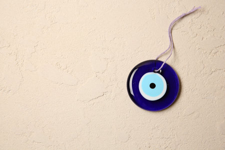 Evil eye amulet on beige textured table, top view. Space for textの写真素材
