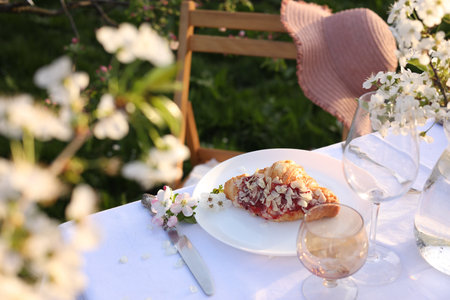 Stylish table setting with beautiful spring flowers in garden