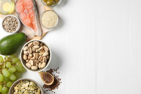 Different products high in natural fats on white wooden table, flat lay. Space for textの写真素材