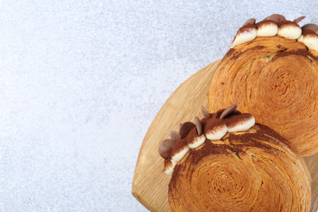 Tasty puff pastry. Supreme croissants with chocolate chips and cream on gray table, top view. Space...