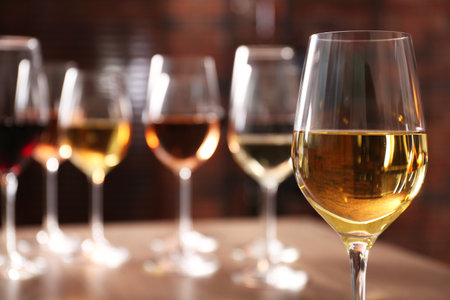 Tasty white wine in glass against blurred background, space for textの写真素材