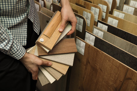 Man with samples of wooden flooring in shop, closeupの写真素材