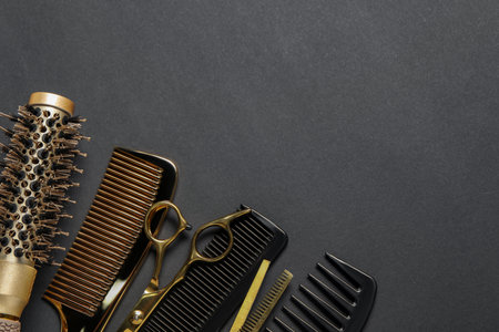 Hairdressing tools on dark table, flat lay. Space for textの写真素材