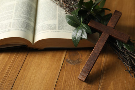 Cross, Bible and green leaves with willow branches on wooden tableの写真素材