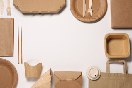 Eco friendly food packaging. Frame of paper containers, bags and tableware on white background, flat lay. Space for textの写真素材