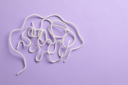 Amnesia problem. Brain made of wires on violet background, top view. Space for textの写真素材