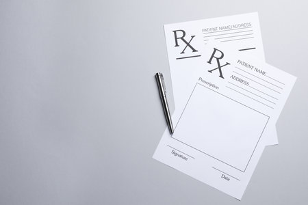 Medical prescription forms and pen on light gray background, flat lay. Space for textの写真素材