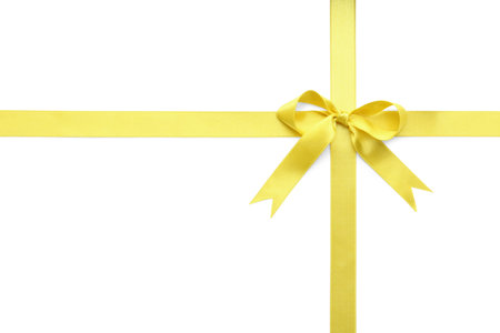Yellow satin ribbon with bow on white background, top viewの写真素材