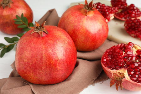 Fresh pomegranates and seeds on white table, closeupの写真素材