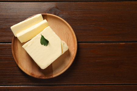 Cut tasty butter on wooden table, top view. Space for textの写真素材