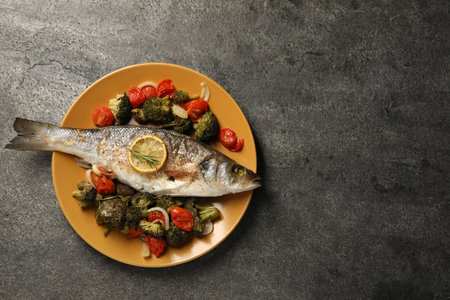 Delicious baked fish and vegetables on gray background, top view. Space for textの写真素材