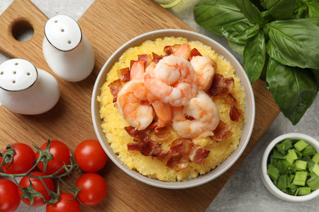Fresh tasty shrimps, bacon and grits in bowl on table, flat layの写真素材
