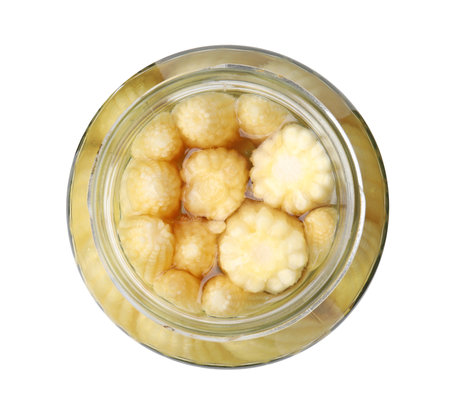 Tasty fresh yellow baby corns in glass jar isolated on white, top viewの写真素材