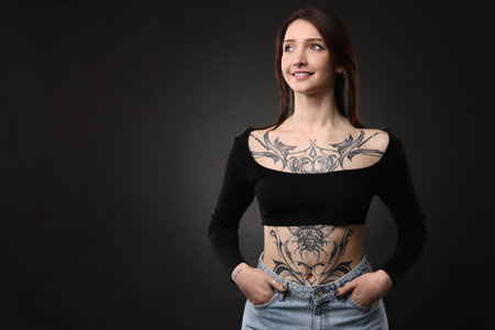 Portrait of smiling tattooed woman on black background. Space for textの写真素材