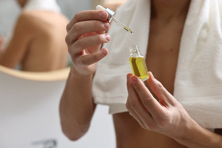 Man with serum in bathroom, closeup view