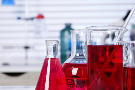 Laboratory analysis. Different glassware with red liquid on table indoors, closeup. Space for textの写真素材