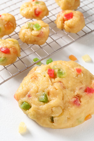 Raw dough with candied fruits on white table, closeup