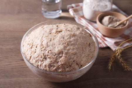 Fresh sourdough in bowl on wooden table, closeupの写真素材