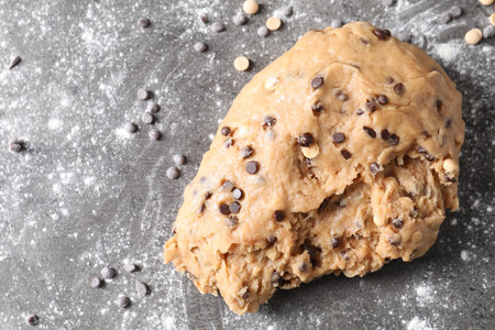 Raw dough with chocolate chips on gray table, top view. Space for textの写真素材