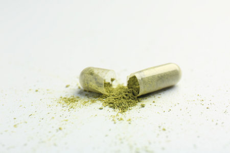 Broken light green vitamin capsule on white background, closeupの写真素材