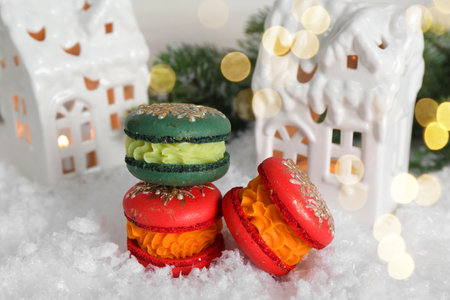 Different decorated Christmas macarons on table with artificial snowの写真素材