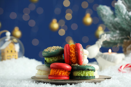 Different decorated Christmas macarons on table with artificial snow against blurred lightsの写真素材