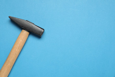 New hammer with wooden handle on light blue background, top view. Space for textの写真素材
