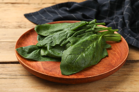 Wet fresh spinach leaves on wooden table, closeupの写真素材