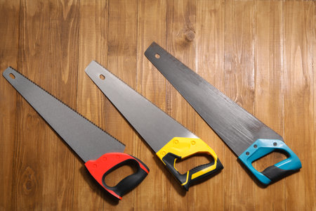 Saws with colorful handles on wooden background, flat layの写真素材