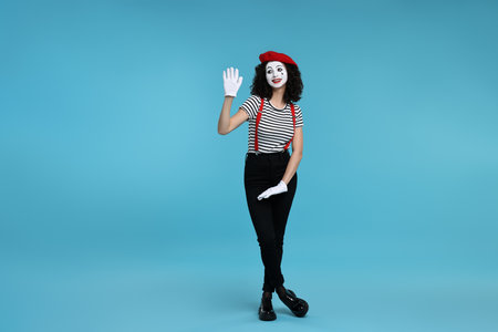 Funny mime with beret posing on light blue backgroundの写真素材