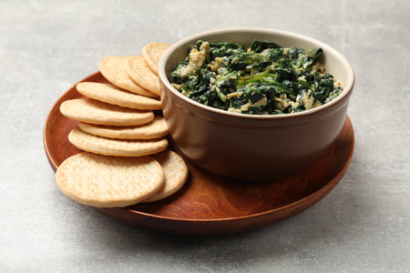 Tasty spinach dip with egg and crackers on gray table, closeupの写真素材