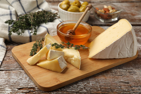 Tasty Camembert cheese with thyme and honey on wooden tableの写真素材