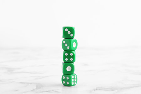 Many stacked green dices on white marble tableの写真素材
