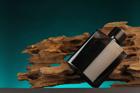 Luxury men`s perfume in bottle on gray table against color background, space for text