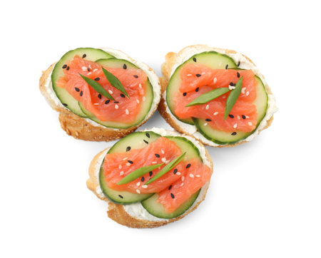 Tasty canapes with salmon, cucumber and cream cheese isolated on white, top viewの写真素材