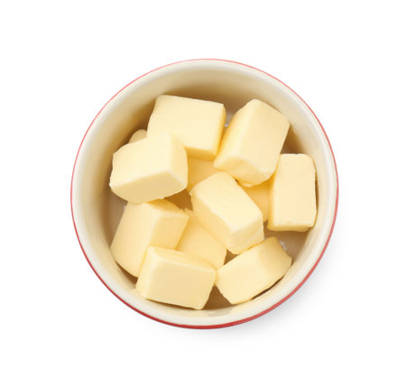 Tasty butter cubes in bowl isolated on white, top viewの写真素材
