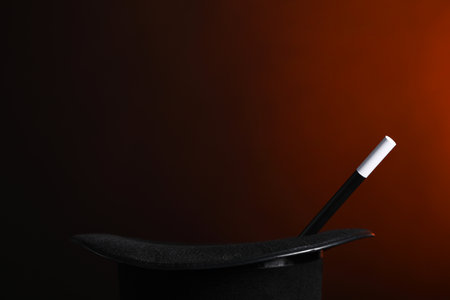 Magician's hat and wand on dark background, closeup. Space for textの写真素材